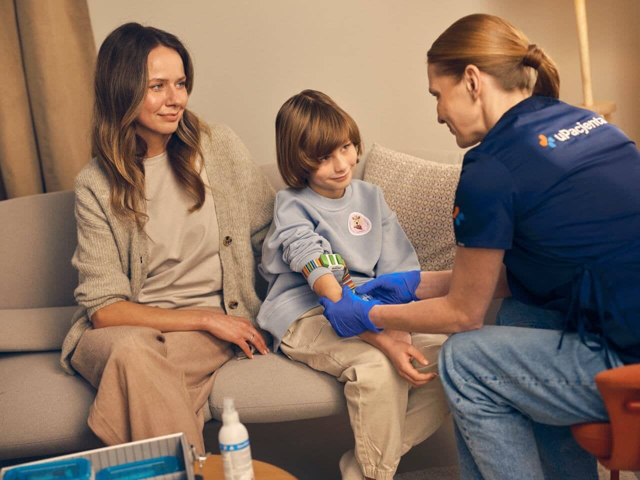 Mama z dzieckiem w domu, spokojne pobranie krwi z doświadczonym medykiem